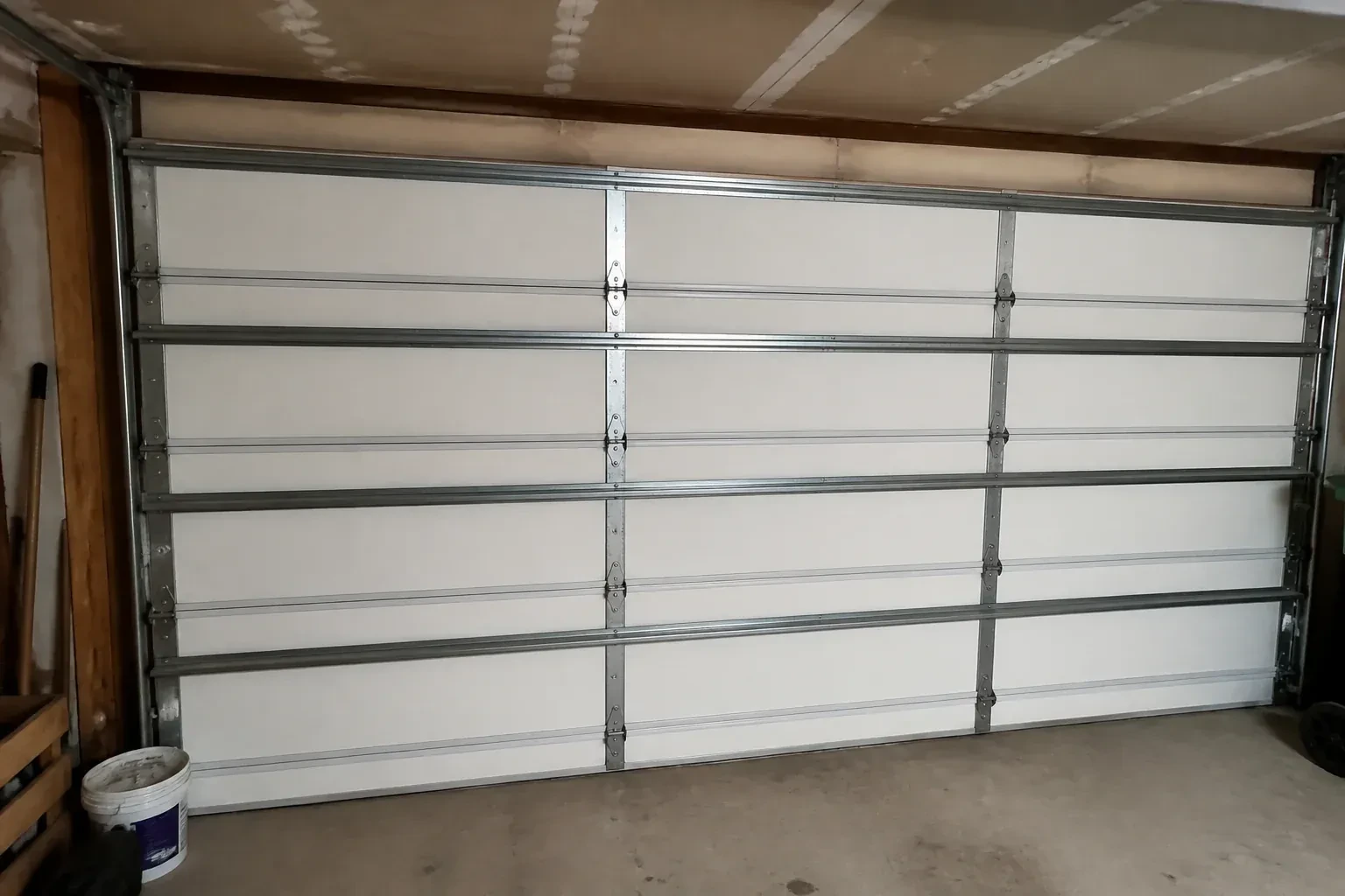 Interior of a closed sectional door with horizontal metal reinforcement struts. — Wind-Rated Garage Door Replacement, Strathcona Gardens
